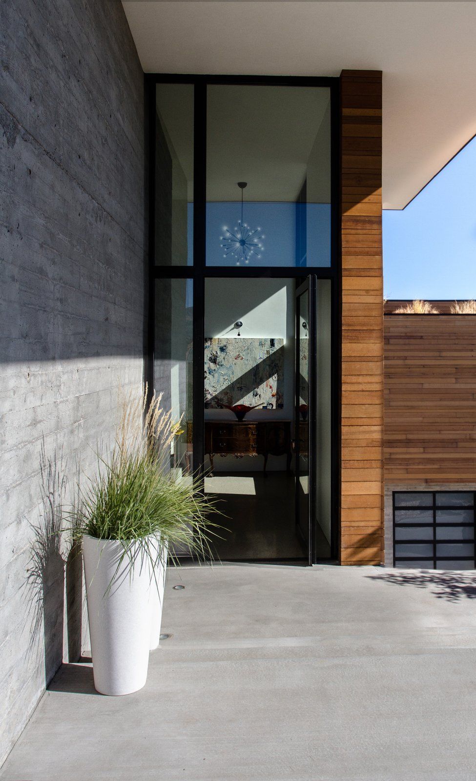 Сочетание бетона, дерева и стекла очень подходит для такого современного дома, как этот.