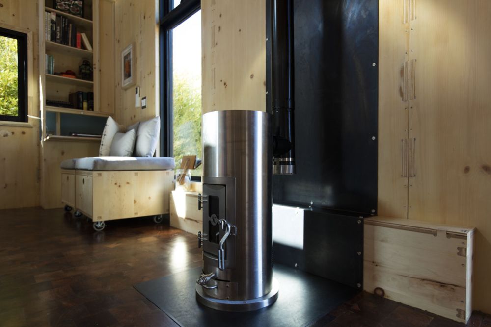 Внутри дровяная печь и мини-сплит система отопления и охлаждения обеспечивают комфорт в доме.