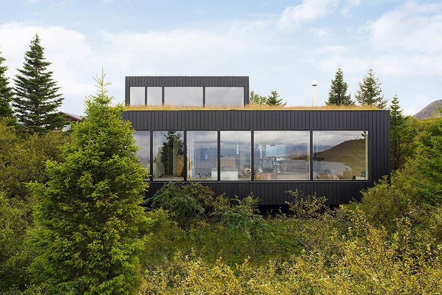 Черная вертикальная облицовка дома также вдохновлена ​​красками ландшафта.