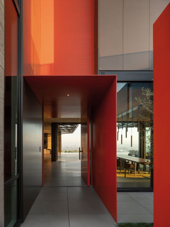 Главный вход отмечен ярко-красными стенами, которые придают фасаду современную динамику.