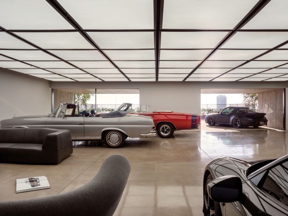 Автомобильная галерея красиво интегрирована в большую открытую планировку нижнего этажа.