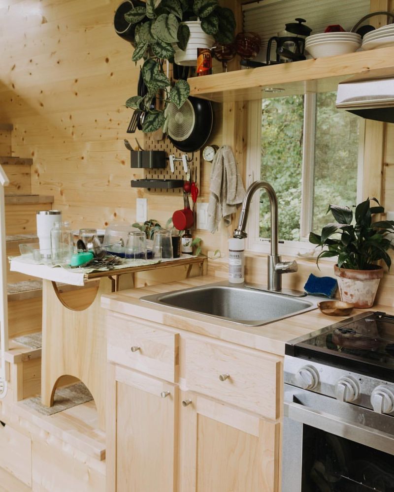 Кухня небольшая, но хорошо оборудованная, с полками для хранения вещей и окном перед раковиной.