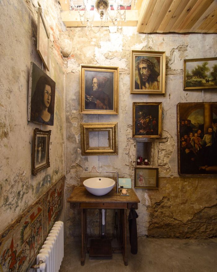 Ванная комната украшена множеством картин в рамах.