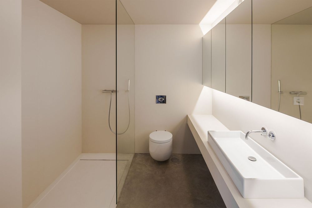 Ванная комната отличается минималистским дизайном и большими зеркалами, которые делают ее больше.