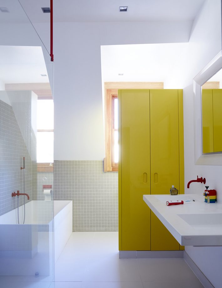 хранение в ванной - высокий желтый шкаф в белой ванной