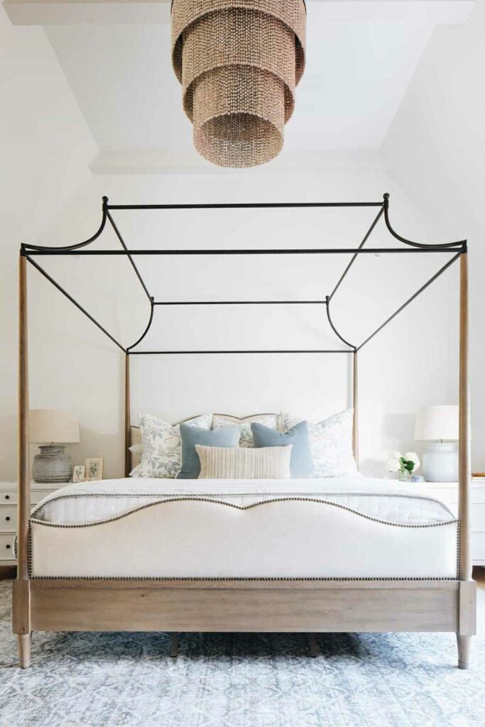 Каркас кровати с балдахином и изогнутое изголовье придают этой комнате очень элегантный вид.