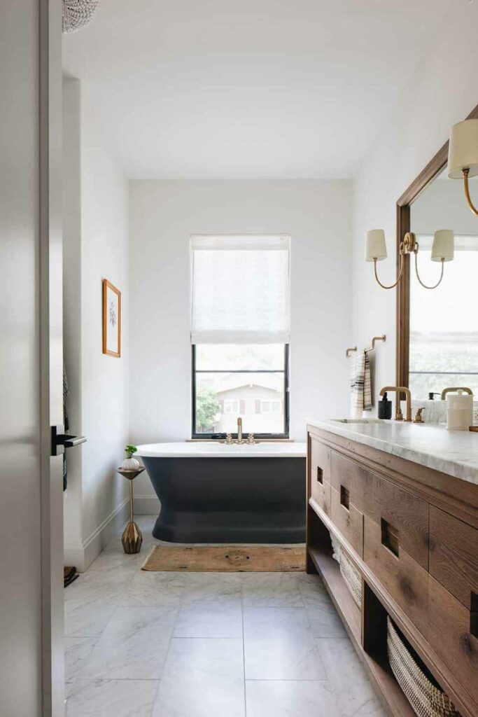 Черная отдельно стоящая ванна соответствует эстетике современного фермерского дома в этом месте.
