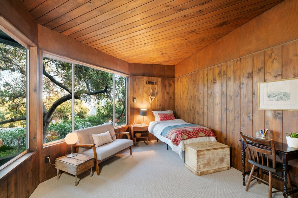 Этот большой дровяной камин создает ощущение уюта в гостиной открытой планировки.