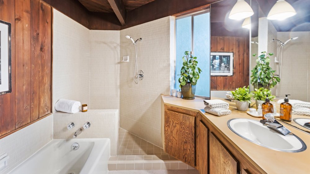 В основной ванной комнате есть угловая душевая кабина и акцентные стены, отделанные деревянными панелями.